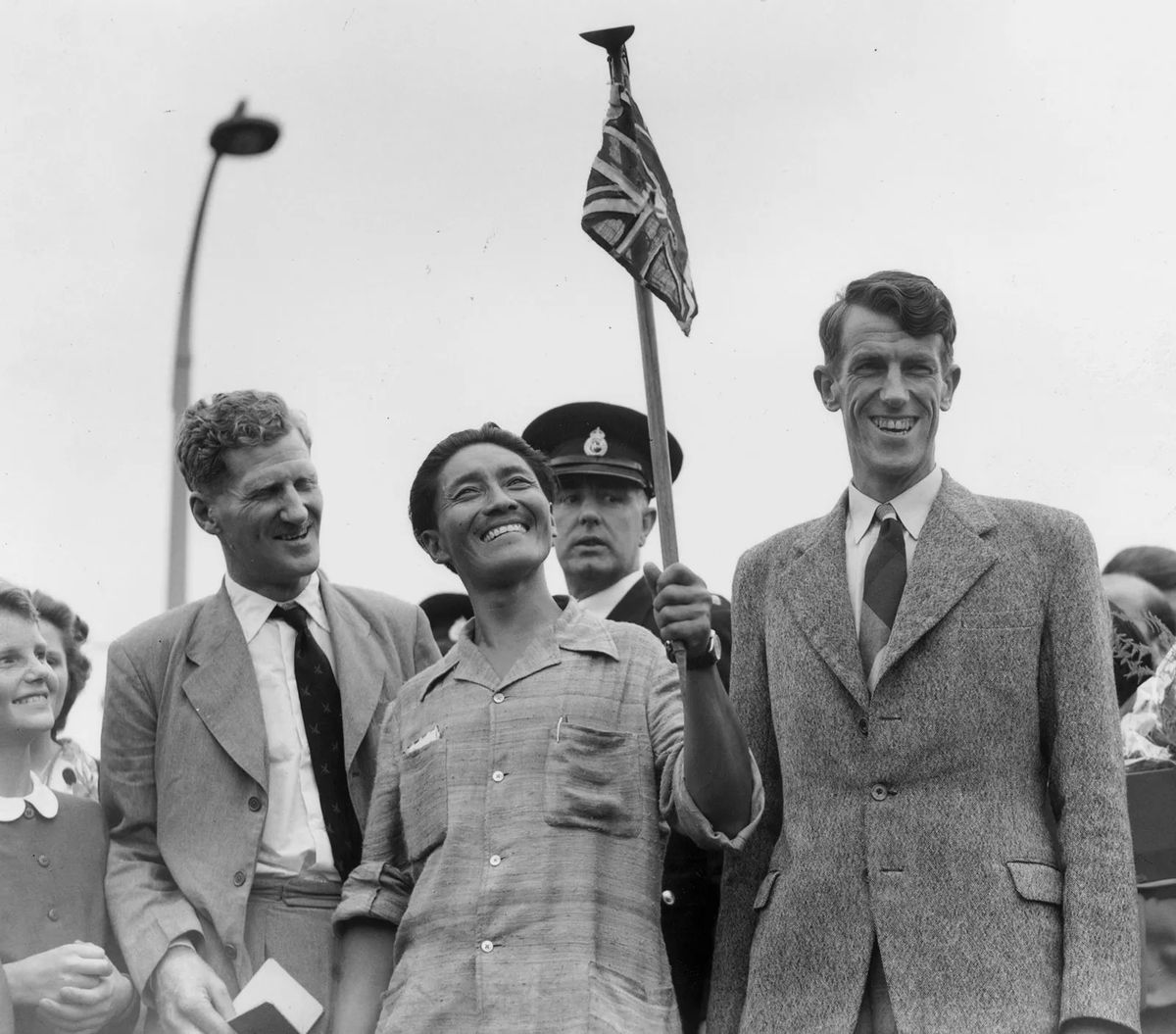 El coronel John Hunt (izquierda), Tenzing Norgay y Edmund Hillary, cuando regresaron a Inglaterra y fueron recibidos con todos los honores. Hunt y Hillary fueron nombrados Caballeros de la Orden del Imperio Británico, mientras que Norgay se convirtió en el primer director de Formación de Campo del Instituto de Montañismo del Himalaya.   El coronel John Hunt (izquierda), Tenzing Norgay y Edmund Hillary, cuando regresaron a Inglaterra y fueron recibidos con todos los honores. Hunt y Hillary fueron nombrados Caballeros de la Orden del Imperio Británico, mientras que Norgay se convirtió en el primer director de Formación de Campo del Instituto de Montañismo del Himalaya.