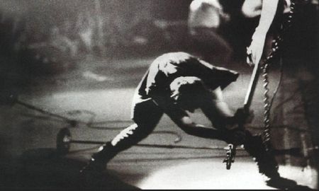 Paul Simonon se desplazaba sobre el escenario enardecido, con su bajo Fender Precision, mientras se acercaba a uno de los laterales, comenzó a azotarlo contra el suelo eufóricamente. Paul Simonon se desplazaba sobre el escenario enardecido, con su bajo Fender Precision, mientras se acercaba a uno de los laterales, comenzó a azotarlo contra el suelo eufóricamente.