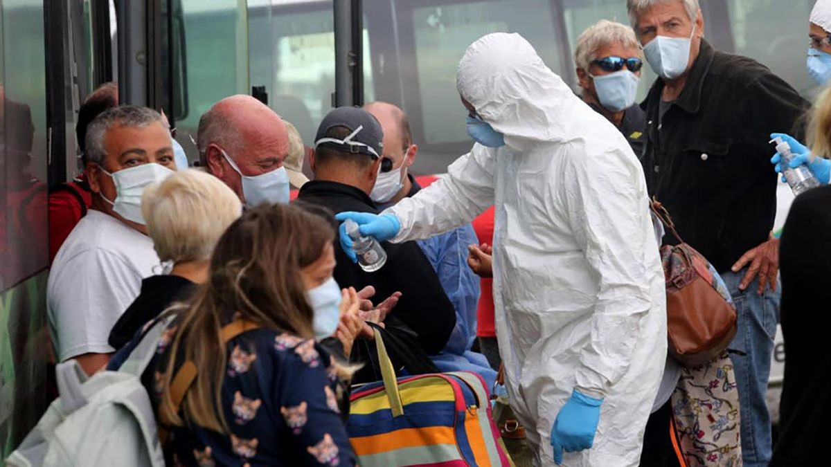 Un agente sanitario paraguayo desinfecta con alcohol en gel las manos de una ciudadana.&nbsp;