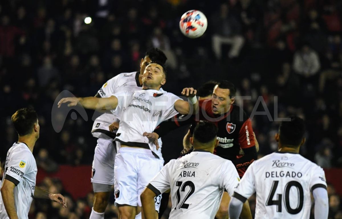 Paolo Goltz y Facundo Garcés luchan con Cristian Lema en el área.